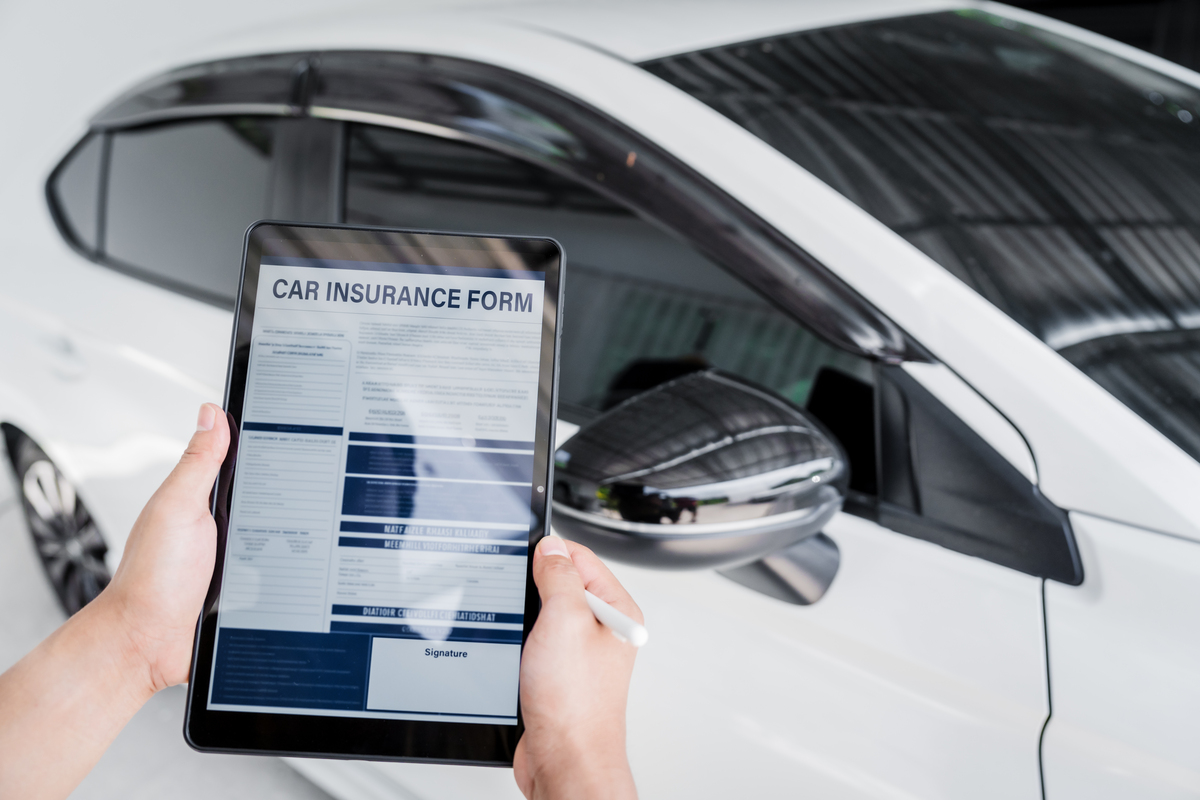 Man fills out a car insurance form after a car accident. Compreh
