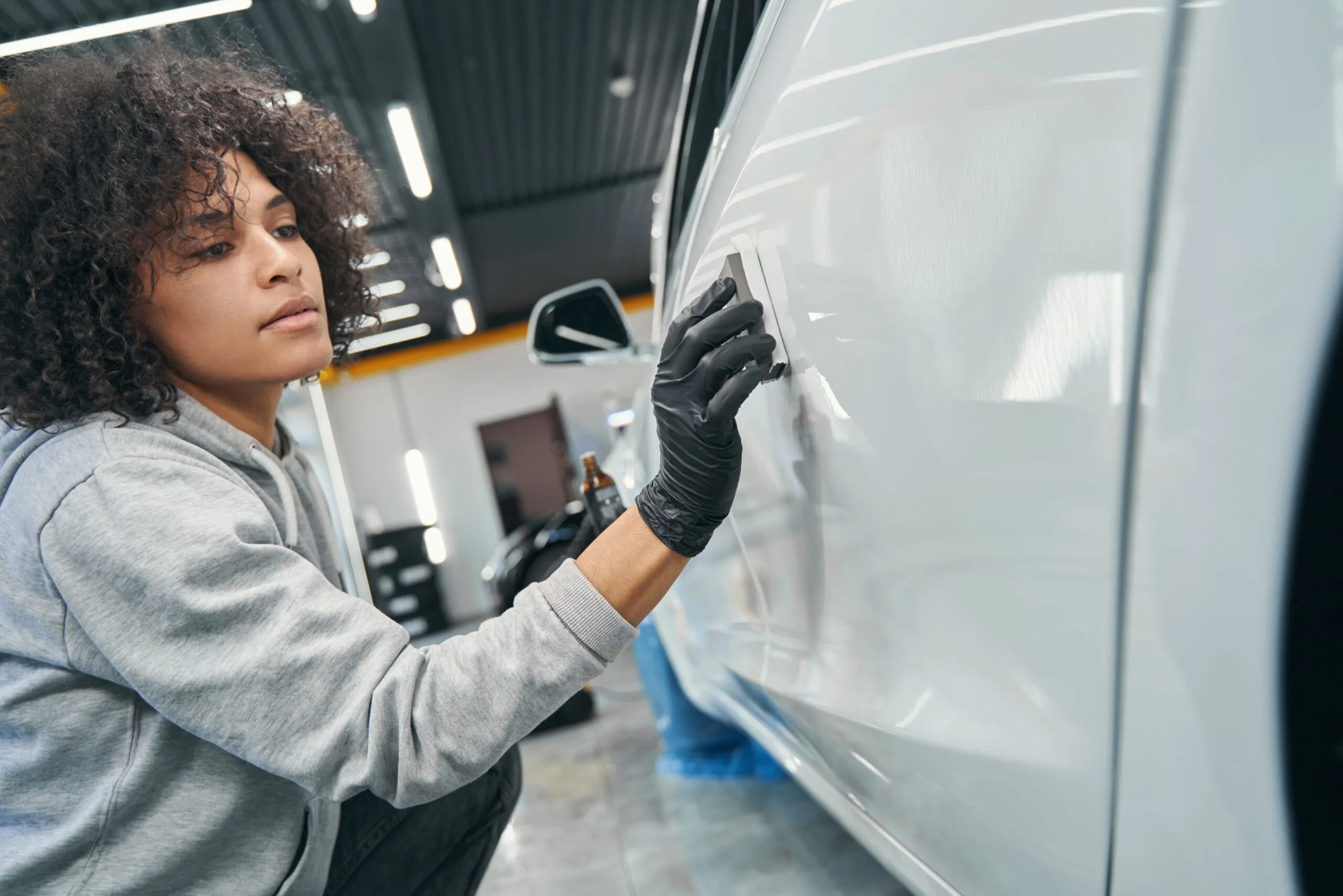 Technician applying ceramic coating to vehicle at A Plus Auto Glass Houston